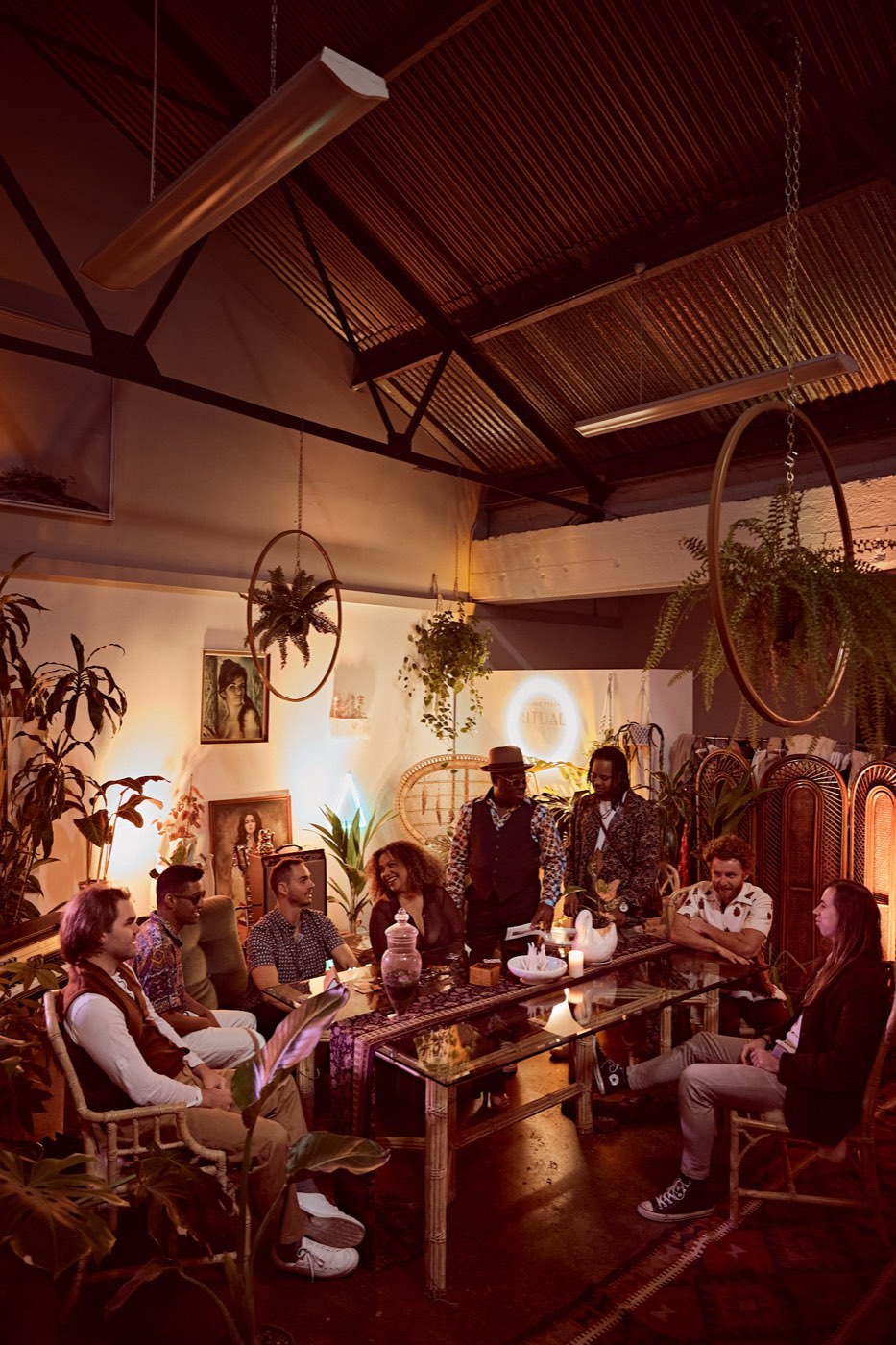 Hipstamatics seated around a long table in a plant-filled warm room